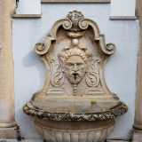 L�acqua sgorga da un grande mascherone e fluisce in una vasca a forma di conchiglia, sui cui lati due colonne reggono un frontone e uno snello arco decorativo